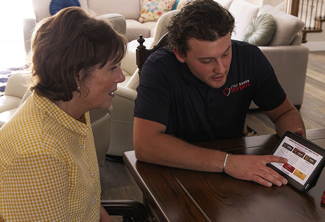 Utah Radon Defense specialist taking a live reading on a radon system inside a Utah home