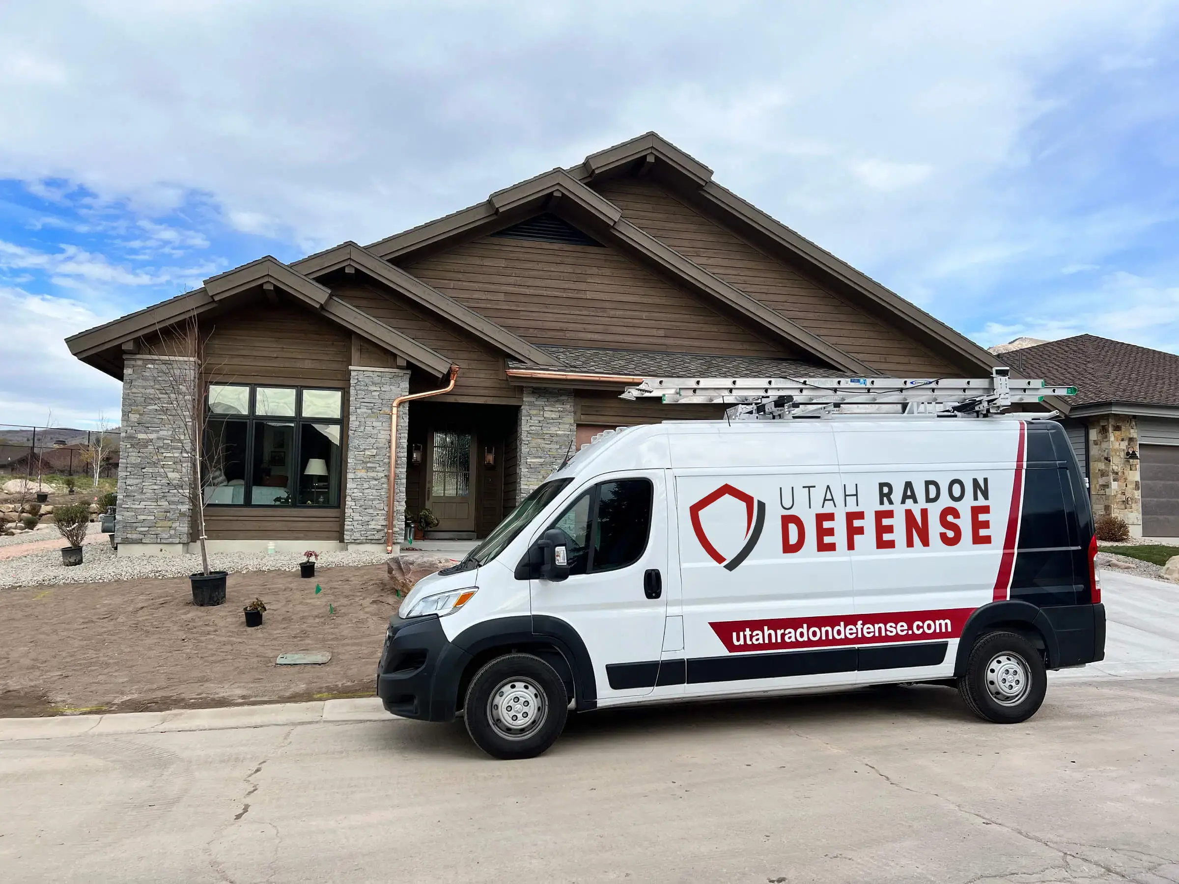Utah Radon Defense van parked in the driveway of a Utah home at golden hour