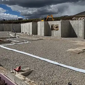 Passive radon system roughed in before the slab pour: clean gravel base, sealed perimeter expansion joint, and vent pipe stub-ups set in the foundation of a new Utah home